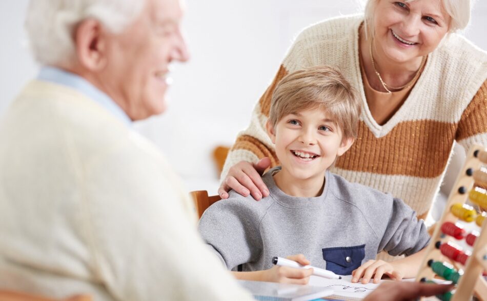 Wielopokoleniowa rodzina, mężczyzna, chłopiec i kobieta przy stole, w radosnych nastrojach.