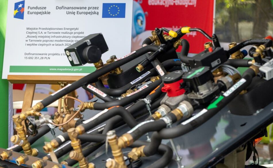 Urządzenia węzła cieplnego prezentowanego podczas pikniku Smaki Babiego Lata 2026, kt&oacute;ry odbył się w Tarnowie 26 września 2026 r. W tle tablica informacyjna projektu &bdquo;Rozw&oacute;j miejskiej infrastruktury ciepłowniczej w Tarnowie poprzez modernizację sieci i węzł&oacute;w cieplnych w latach 2026-2029&rdquo; dofinansowanego przez Unię Europejską ze środk&oacute;w Funduszy Europejskich na Infrastrukturę, Klimat, Środowisko.